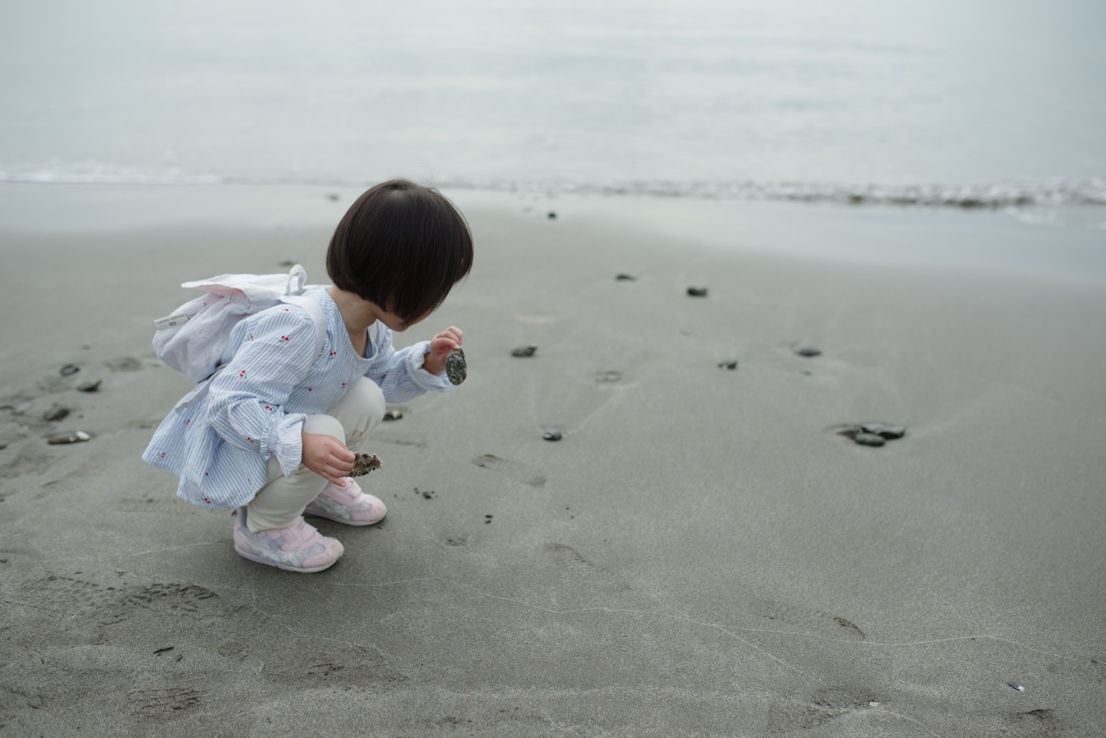一色海岸の砂浜で貝殻を拾う娘。PENTAX K-1 Mark IIとSIGMA 35mm F1.4 Artで撮影。