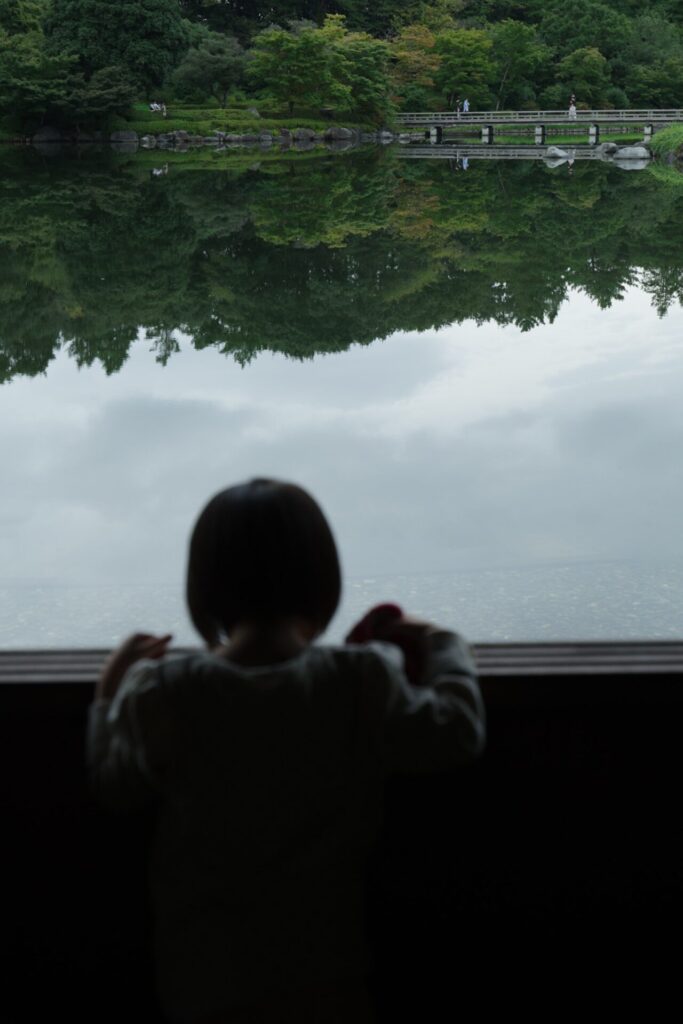 昭和記念公園の池を眺める子どもの後ろ姿