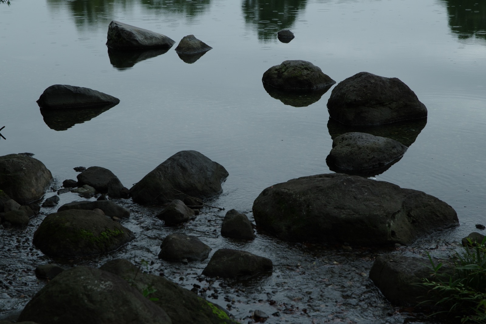 静かな水面に浮かぶように見える岩