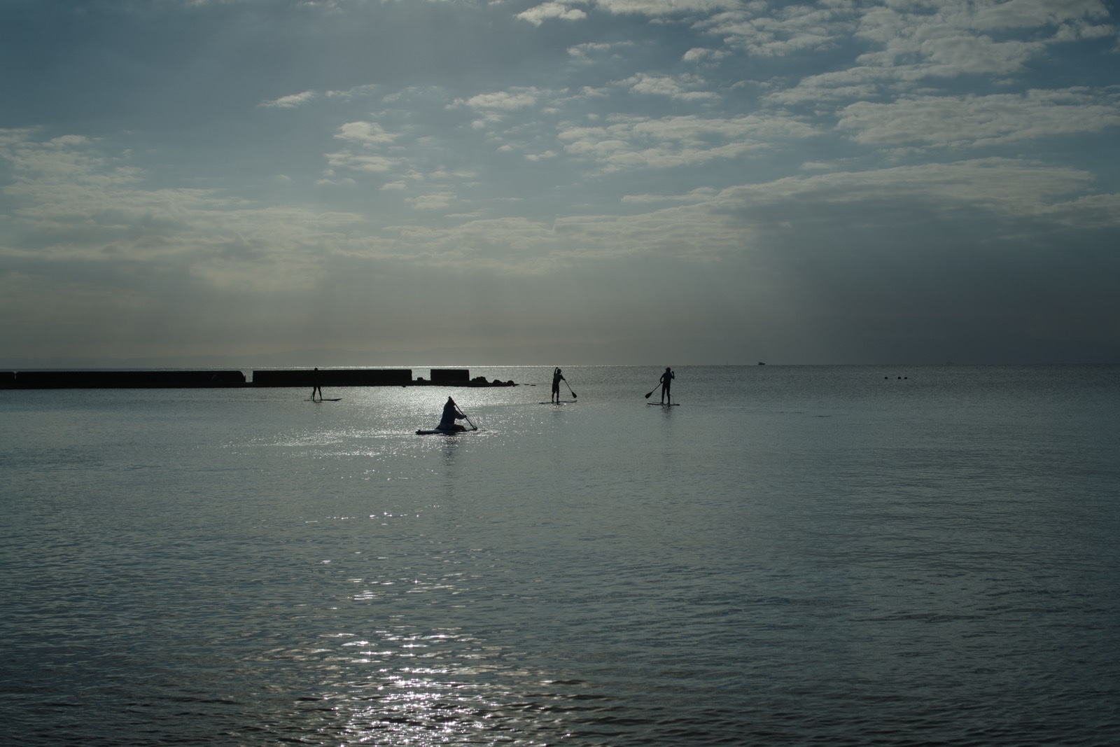 光が反射する一色海岸の海面とSUPを楽しむ人々。PENTAX K-3 Mark IIIとFA31mm Limitedで撮影。